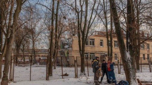 Communal workers stand in the snow next to a kindergarten that was recently damaged during Russian ...