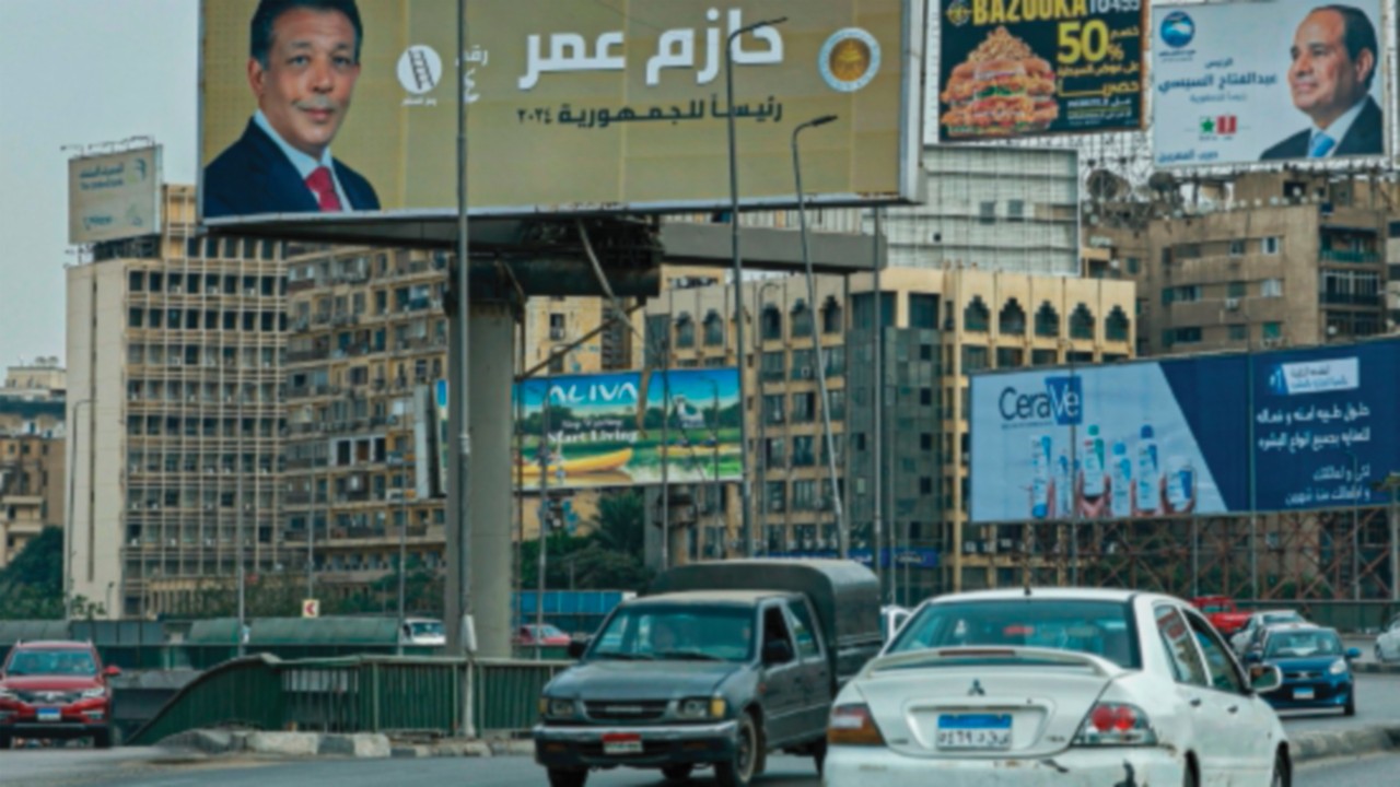 Motorists drive past campaign billboards of Egypt's President Abdel Fattah al-Sisi and presidential ...