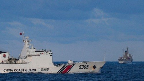TOPSHOT - A Chinese Coast Guard ship sails near a Philippine vessel (R) that was part of a convoy of ...