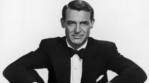 circa 1953:  British actor and comedian Cary Grant (1904 - 1986) sits with his legs crossed in a ...