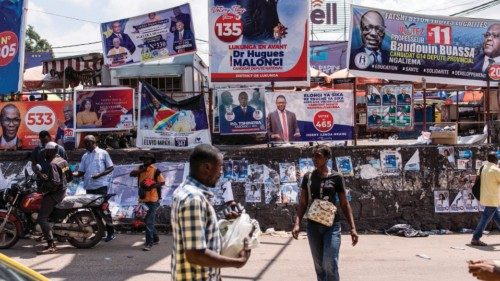 People walk past election campaign banners and posters at popular Kintambo round about in Kinshasa ... People walk past election campaign banners and posters at popular Kintambo round about in Kinshasa ...