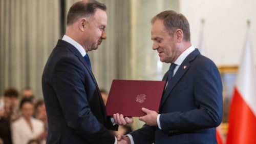 Poland's President Andrzej Duda (L) hands the assignment document to Donald Tusk to designate him as ... Poland's President Andrzej Duda (L) hands the assignment document to Donald Tusk to designate him as ...