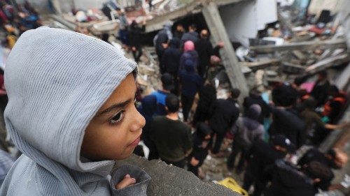 A child looks on as Palestinians inspect the damage at the site of Israeli strikes on houses, amid ... A child looks on as Palestinians inspect the damage at the site of Israeli strikes on houses, amid ...