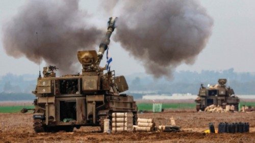 An Israeli army self-propelled artillery howitzer fires rounds from a position near the border with ...