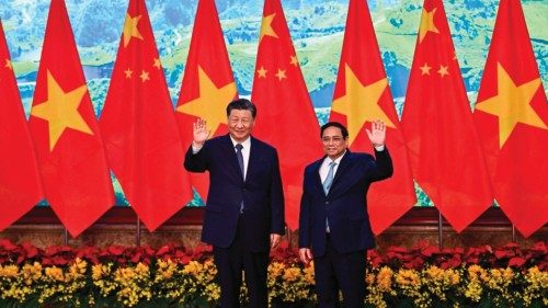 TOPSHOT - Vietnam's Prime Minister Pham Minh Chinh (R) and China's President Xi Jinping (L) wave to ...
