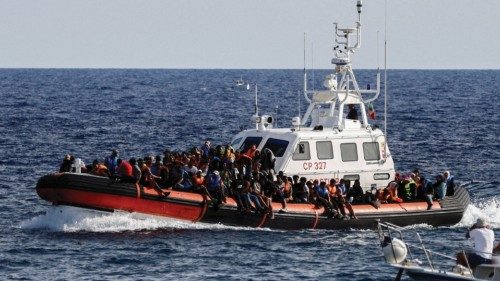 FILE PHOTO: An Italian Coast Guard vessel carrying migrants rescued at sea passes near a tourist ... FILE PHOTO: An Italian Coast Guard vessel carrying migrants rescued at sea passes near a tourist ...