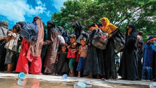 Newly-arrived Rohingya refugees wait to board trucks to transfer to a temporary shelter after ...