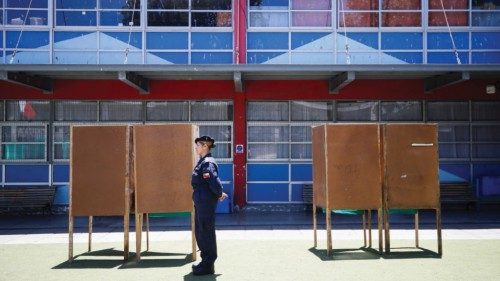 A Chilean Navy officer stands guard next to voting booths before the constitutional referendum which ...