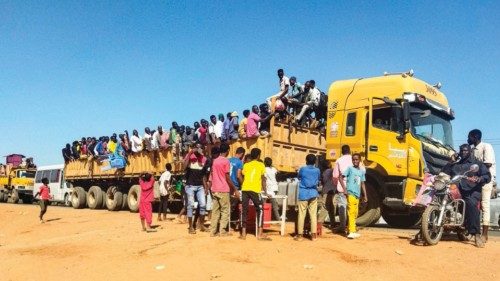 People displaced by the conflict in Sudan get on top of the back of a truck moving along a road in ... People displaced by the conflict in Sudan get on top of the back of a truck moving along a road in ...