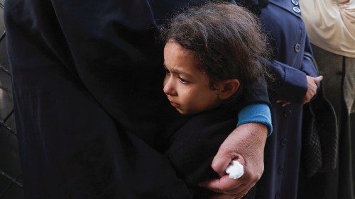 A child reacts while holding a person near the bodies of Palestinians killed in Israeli strikes at a ... A child reacts while holding a person near the bodies of Palestinians killed in Israeli strikes at a ...