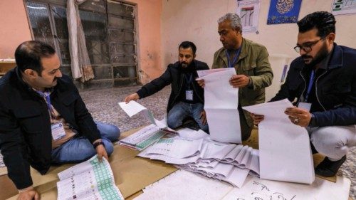 Election Commission employees count ballots at a polling station in Sadr City in eastern Baghdad on ...