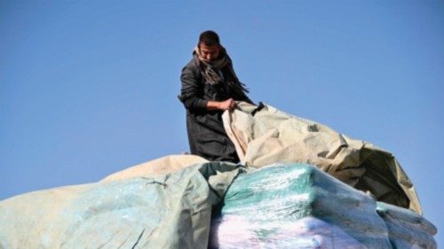 TOPSHOT - A truck driver unloads his humanitarian aid cargo for inspection upon arriving from Egypt ... TOPSHOT - A truck driver unloads his humanitarian aid cargo for inspection upon arriving from Egypt ...