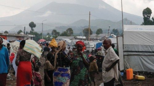 Internally displaced Congolese people gather outside their makeshift shelter before voting at the ... Internally displaced Congolese people gather outside their makeshift shelter before voting at the ...