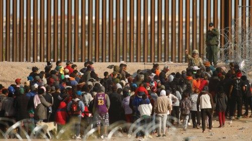 Migrants gather near the border wall after crossing the Rio Bravo river with the intention of ...
