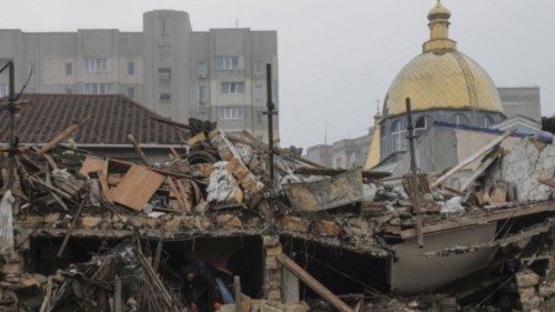 A local resident removes debris at the site where a residential building was destroyed during a ...