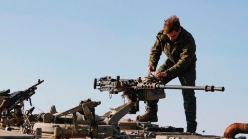 An Israeli soldier checks a weapon at a position in the Israel-annexed Golan Heights near the border ...
