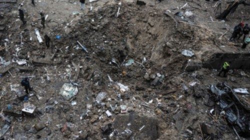 People stand next to a crater at a site of a Russian missile strike, amid Russia's attack on ... People stand next to a crater at a site of a Russian missile strike, amid Russia's attack on ...