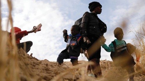 David, a 4-year-old Haitian migrant child, is held by the hand of his mother before crossing the Rio ...
