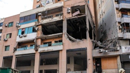 TOPSHOT - Lebanese civil defence members spray with water the street by the building that was hit by ... TOPSHOT - Lebanese civil defence members spray with water the street by the building that was hit by ...