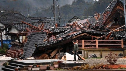 A man walks past a collapsed house in Anamizu Town, Ishikawa prefecture on January 3, 2024, after a ...