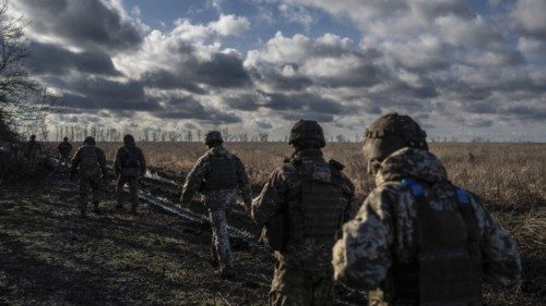 Ukrainian servicemen of the 55th Separate Artillery Brigade walk at a position near the front line ...