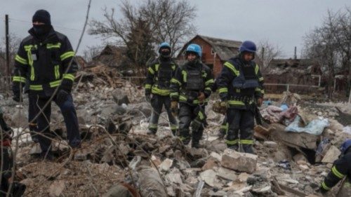 Rescuers with a dog work at the site of a Russian missile strike in an area in the village of Rivne ...