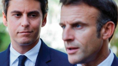 (FILES) French Education and Youth Minister Gabriel Attal (L) looks at France's President Emmanuel ...