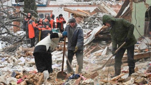 TOPSHOT - Rescuers and local residents clear debris following Russian strikes, in Zmiiv, Kharkiv ...