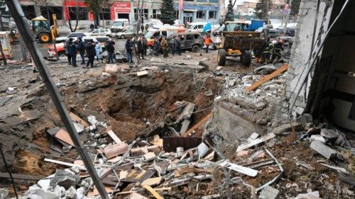 Rescue workers clear rubble around a crater near a destroyed hotel after a missile attack in ...