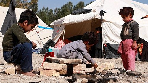 Afghan children play outside their makeshift shelters at a camp set-up after earthquake on the ...