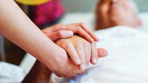 Cropped image of healthcare worker holding patient's hand. Close-up of nurse consoling patient. They ...