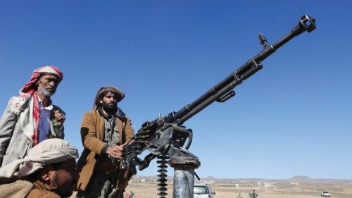 Tribal supporters of the Houthi group ride on the back of a pick-up truck during a protest against ...