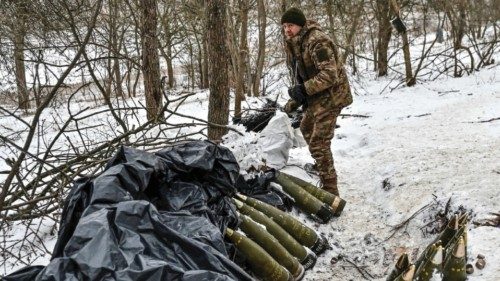 A Ukrainian serviceman stands next to 155-mm artillery shells at a position near a front line, amid ...