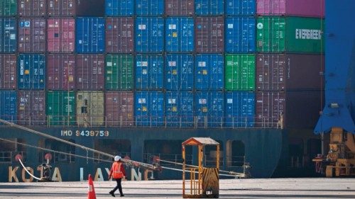 This picture taken on January 11, 2024, a worker walks near a cargo ship docked at Mundra Port, ...