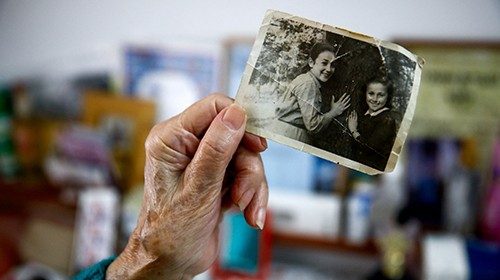 Ester Liber, a Holocaust survivor, shows a photo of herself and her sister, as she leaves to take ...
