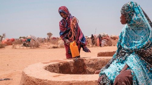 Women stand next to a water well in the camp for internally displaced people of Farburo 2 in the ...