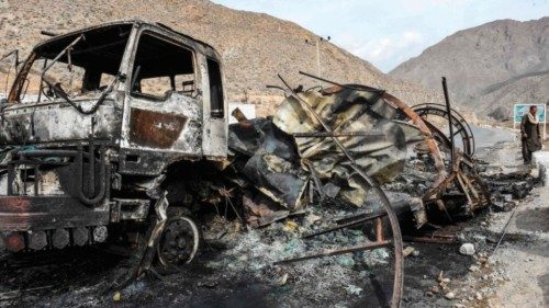 TOPSHOT - A man walks past a charred truck container torched by armed separatist group Balochistan ...