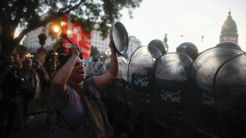 A woman bangs a lid as demonstrators protest outside the National Congress on the day of the debate ...
