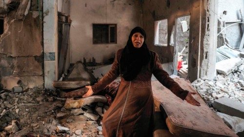 TOPSHOT - A Palestinian woman cries as she inspects a heavily damaged apartment following Israeli ...