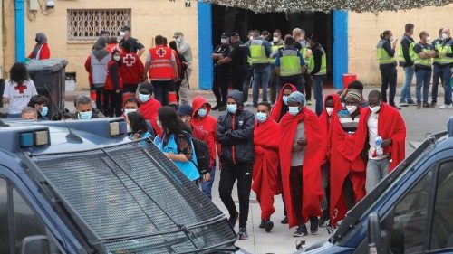 FILE PHOTO: Migrants walk outside a facility prepared for them, accompanied by members of a NGO and ...