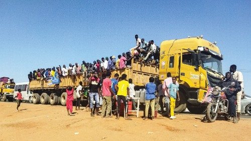 People displaced by the conflict in Sudan get on top of the back of a truck moving along a road in ... People displaced by the conflict in Sudan get on top of the back of a truck moving along a road in ...