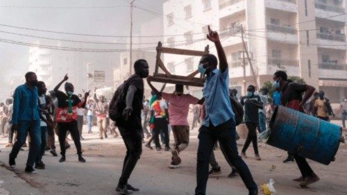 Protesters shout slogans and collect barrels and tables to burn during clashes with police on the ...