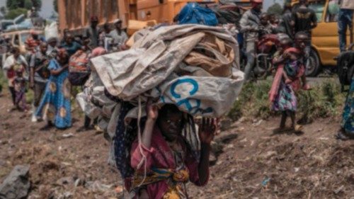 TOPSHOT - A young boy carries some of his belonging as people flee the Masisi territory following ... TOPSHOT - A young boy carries some of his belonging as people flee the Masisi territory following ...