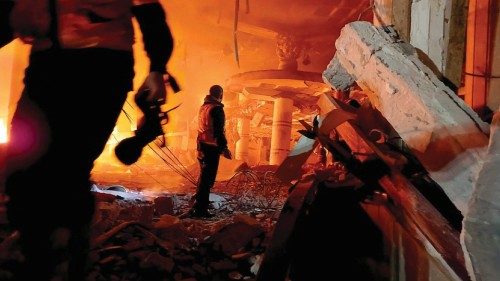 A member of the Palestinian Civil Defence works at the site of Israeli strikes, amid the ongoing ...