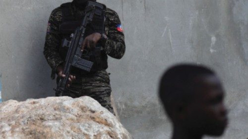 A Haitian National Police officer keeps watch near the scene where agents of Haiti's BSAP, an armed ...
