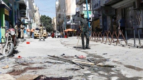 A Somali police officer stands guard at the scene after an explosion at the Bakara market in ...