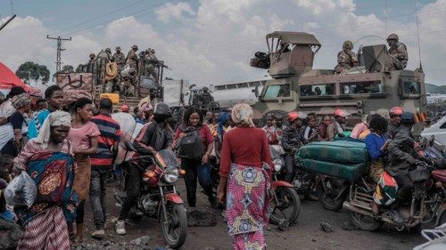(FILES) People gather next to some vehicles from the South African National Defence Force (SANDF) as ...