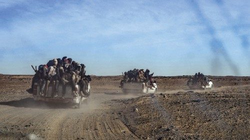 A picture taken from a vehicle and through a window shows a group of migrant men, mainly from Niger ... A picture taken from a vehicle and through a window shows a group of migrant men, mainly from Niger ...