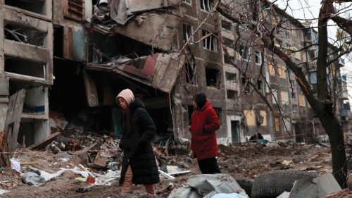 Local residents walk past an apartment building destroyed by a Russian missile attack in the town of ... Local residents walk past an apartment building destroyed by a Russian missile attack in the town of ...