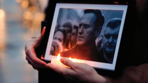 A protester holds candles and a picture of the late opposition leader Alexei Navalny, during a ... A protester holds candles and a picture of the late opposition leader Alexei Navalny, during a ...